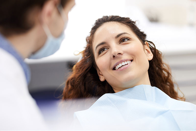 patient smiling brightly while getting examined by doctor
