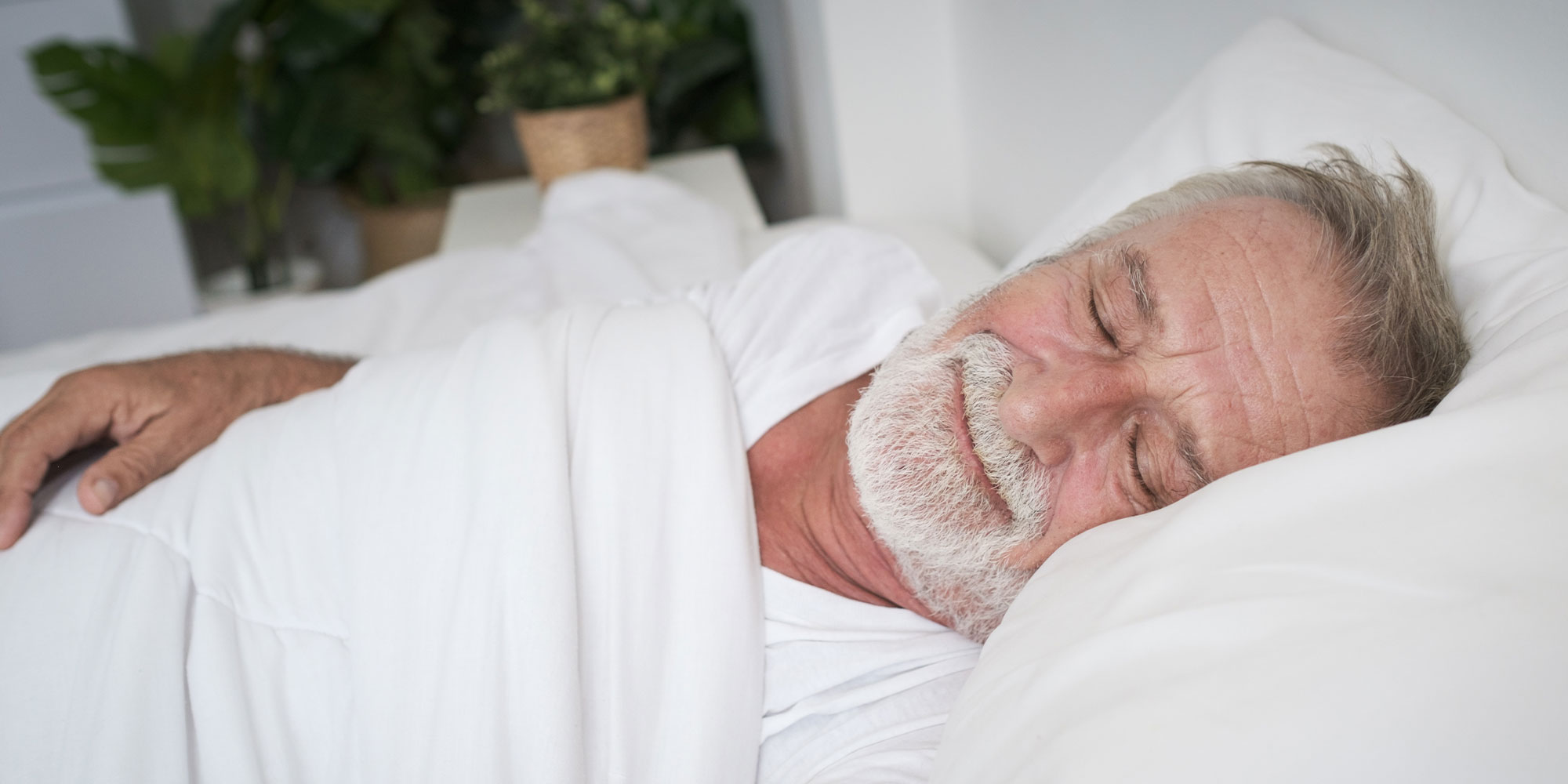 older male sleeping comfortable within their bed