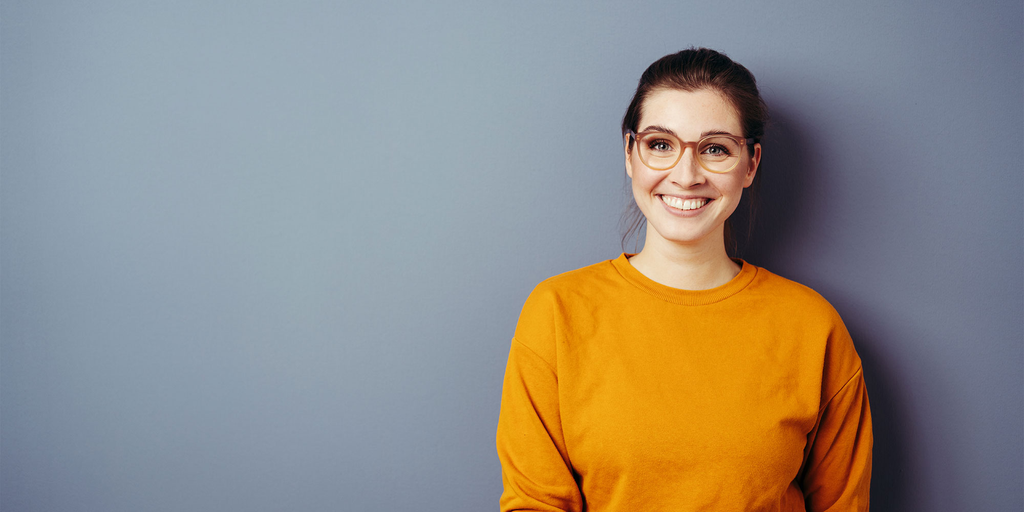 Vivacious young woman wearing glasses and an orange top